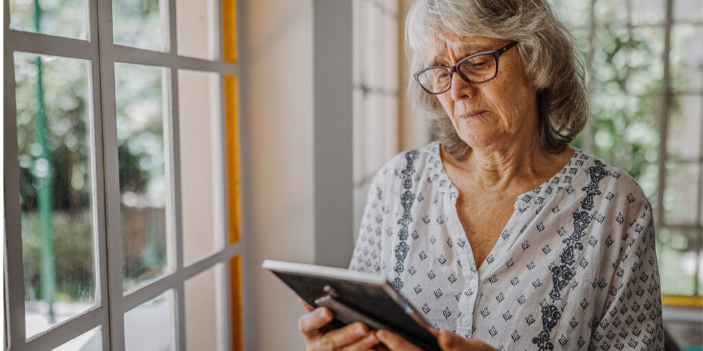 mature woman looking at picture frame